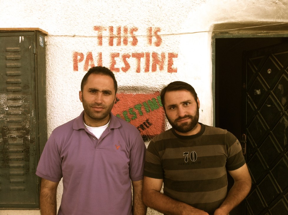 Brothers Issa and Ahmed Amro, nonviolent activists and organizers, stand outside of their community center in occupied Hebron.  