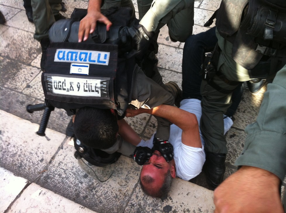 Police arrest a Palestinian man during "Jerusalem Day," 2014